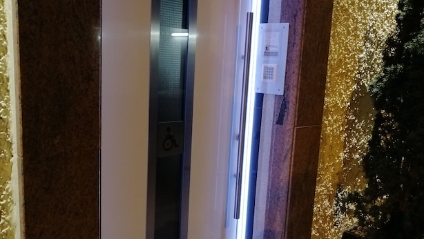 An elevator with a wheelchair accessibility symbol, a control panel, and a sign indicating 'Terminal 1'. - Appartment Graz Zentrum (Graz)
