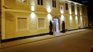 A building with a textured facade, multiple windows, and a lit entrance. - Appartment Graz Zentrum (Graz)