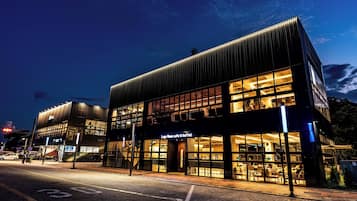 Un edificio moderno con caffetteria e buffet, caratterizzato da ampie vetrate e una facciata luminosa.