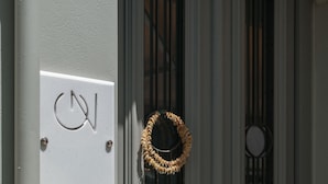 Una puerta gris con un adorno festivo y un buzón.