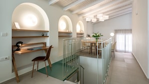 Un interior moderno con comedor, escalera y cocina.