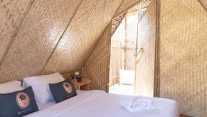 Una tienda acogedora de una sola habitación con cama, almohadas y mesita de noche.