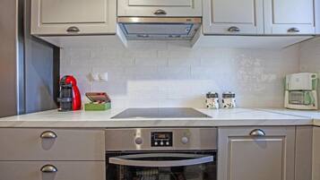 A modern kitchen with stainless steel appliances, a built-in oven, and a coffee maker.
