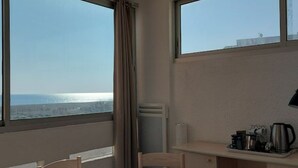 A room with a view of the sea, a radiator, a desk with a kettle, and a chair. - Logement Front de mer à Port Leucate (Leucate)