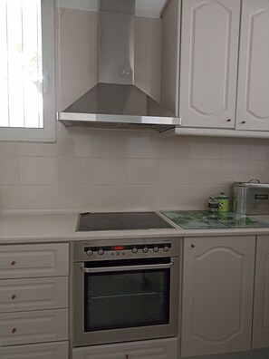Departamento, varias camas | Cocina privada | Refrigerador, horno, lavavajillas y tetera eléctrica 