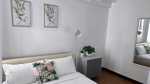 Una camera da letto con un letto grande, un comodino con una lampada e due quadri appesi al muro.