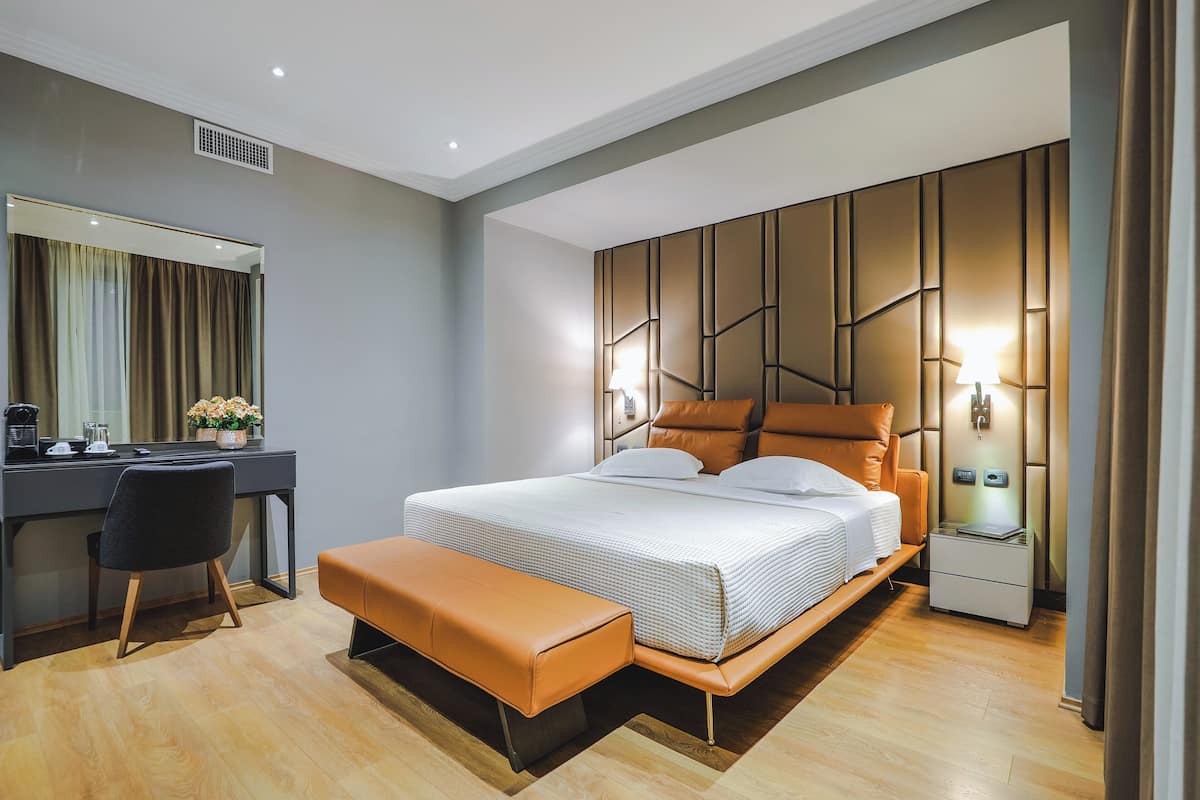 Ein modernes Schlafzimmer mit Bett, Nachttisch und Schreibtisch mit Stuhl.