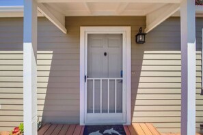 A white door with a glass panel and a small window, set in a beige house with a porch. - Now a Private Yard! W/ spa, firepit, grill, pets (San Diego)