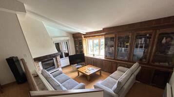 TV connectée, cheminée, table de tennis de table, livres