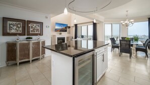 Una cocina moderna con una isla central, un comedor con vistas y un espacio de sala de estar con chimenea.