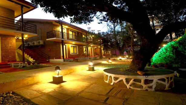 A two-story building with a balcony, outdoor lighting, and a landscaped garden area. - MeroStay 110 Cottage (Kathmandu)