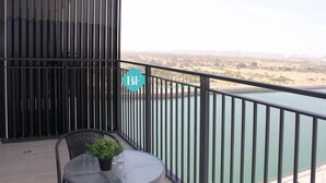 Un balcone con vista su uno specchio d'acqua ed edifici in lontananza.