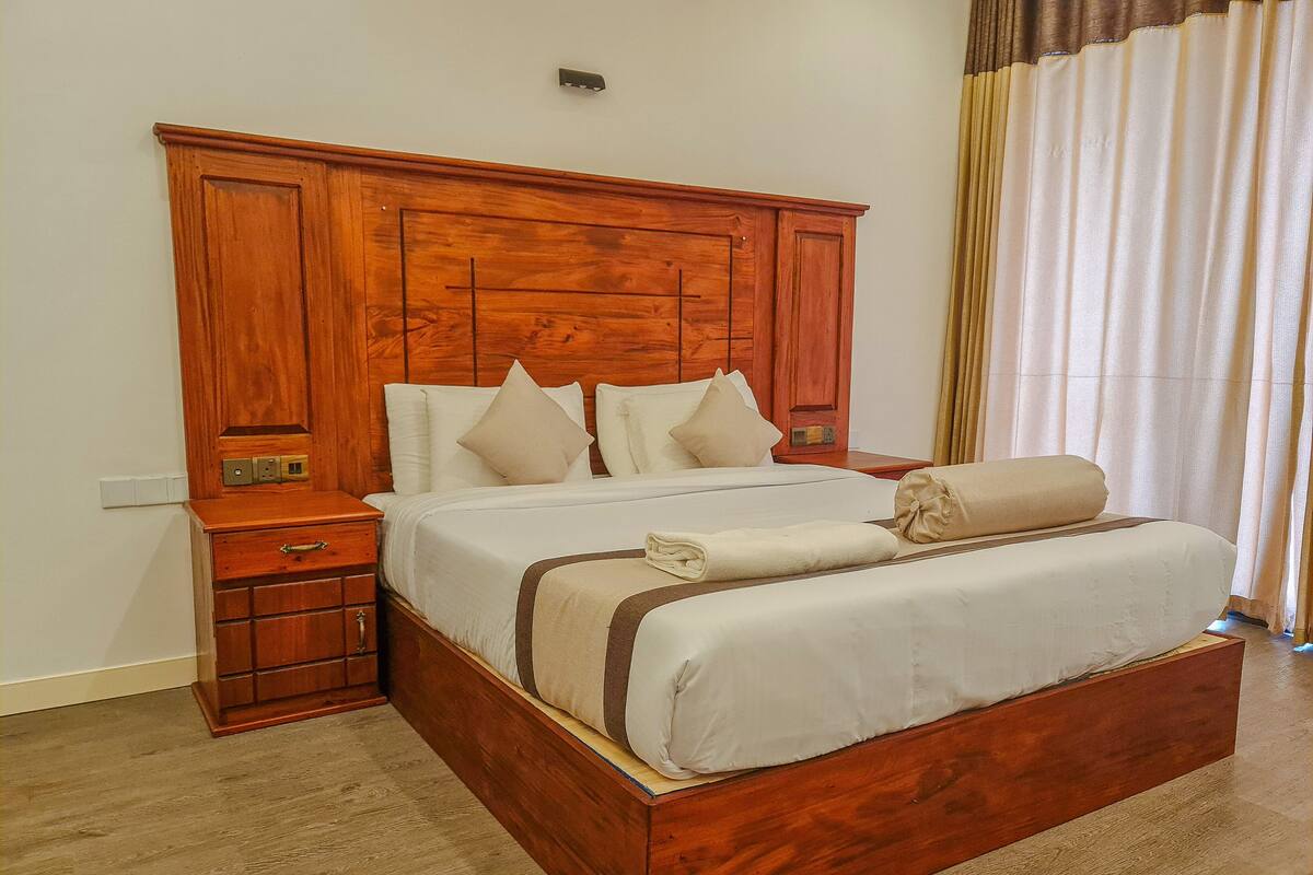 A wooden bed with a headboard, a nightstand, and a drawer unit.