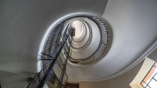 A spiral staircase with ornate metal railings and a central column, leading to an upper floor. - Lovely and new apartment near Termini Station (Roma)