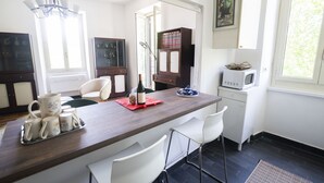 Eine moderne Küche mit einer Holzausziehtheke, weißen Stühlen und einem Essbereich.