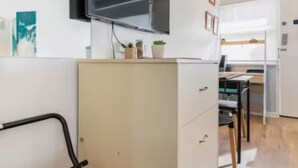 A modern office space with a desk, chair, and a cabinet.