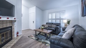 A living room with a fireplace, a sofa, a coffee table, and a television.