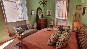 A bedroom with a bed, a dresser, a chair, a window, and a lamp. - Cosy apartment for 6 guests with WIFI, A/C, TV and pets allowed (Lucca)