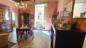 A dining area with a round table, chairs, a chandelier, and a cabinet with glass doors. - Cosy apartment for 6 guests with WIFI, A/C, TV and pets allowed (Lucca)