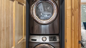 A compact, built-in washer and dryer unit with a wooden finish and a control panel. - Long Lake Retreat in Phillips, Wisconsin (Phillips)