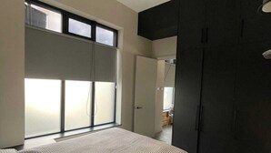 Ein Schlafzimmer mit einem großen Bett, einem Deckenventilator, einem Kleiderschrank und einem Fenster.