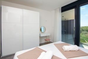 Habitación de hotel moderna con una cama grande, un escritorio y vistas al exterior.