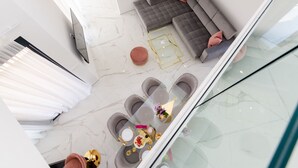 Un espacio moderno con una sala en seccional, una mesa de centro de vidrio y un juego de comedor.