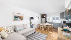 A modern apartment with a living room, dining area, and kitchen.