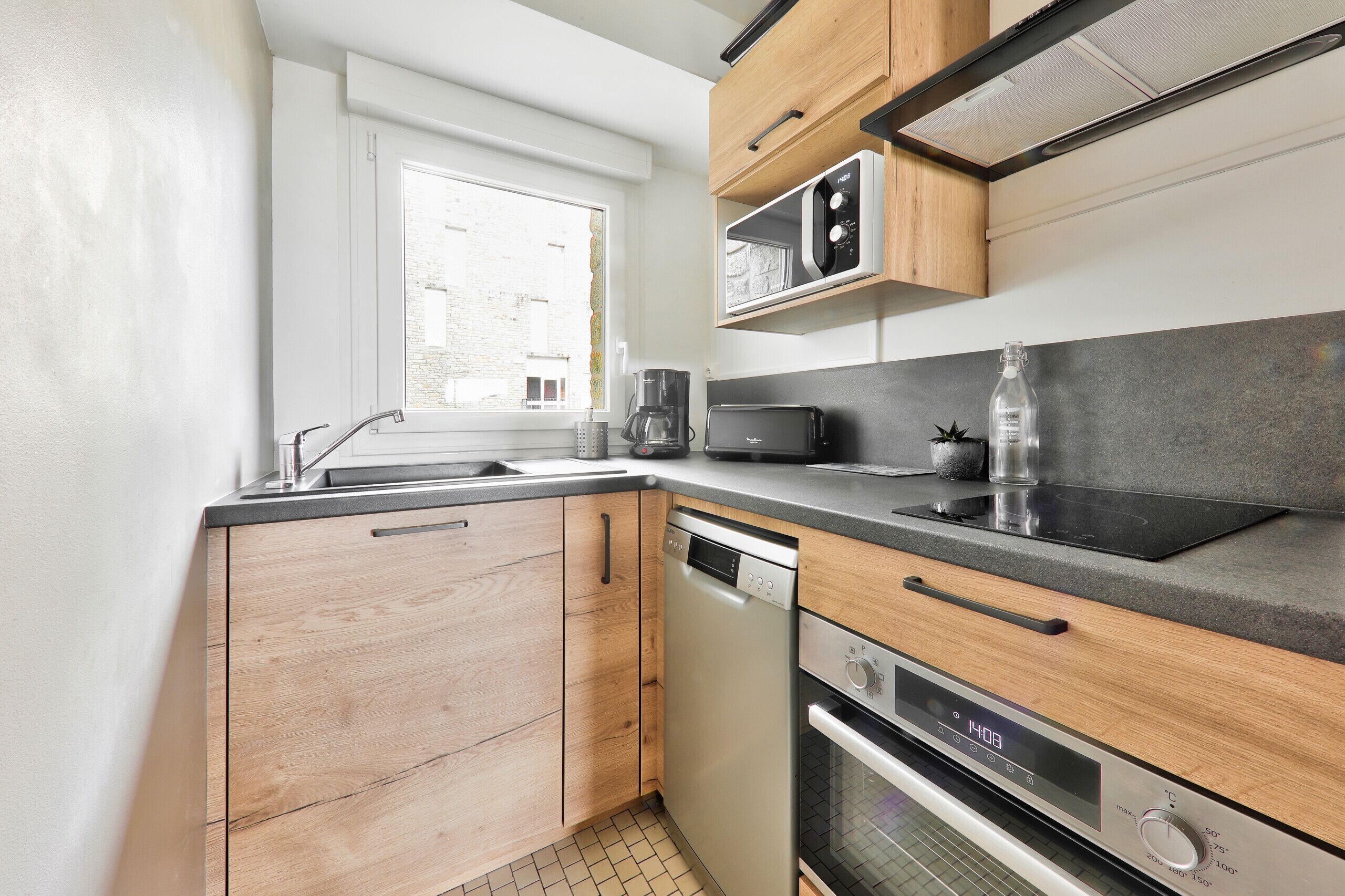 A modern kitchen with wooden cabinets, a built-in microwave, a toaster, and a dishwasher.