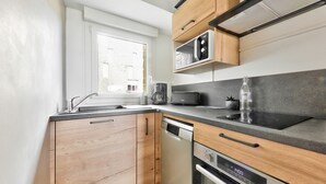 Une cuisine moderne avec des meubles en bois, un four à micro-ondes encastré, un grille-pain et un lave-vaisselle.