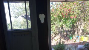 Een kamer met een raam dat uitzicht biedt op een tuin.