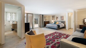 Une chambre spacieuse avec un lit, un canapé et une grande fenêtre.