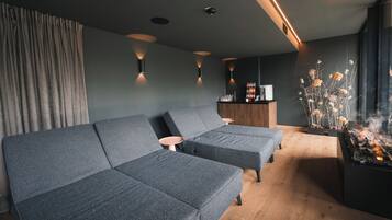 Een moderne woonkamer met een hoekbank, een bijzettafeltje en een open haard.