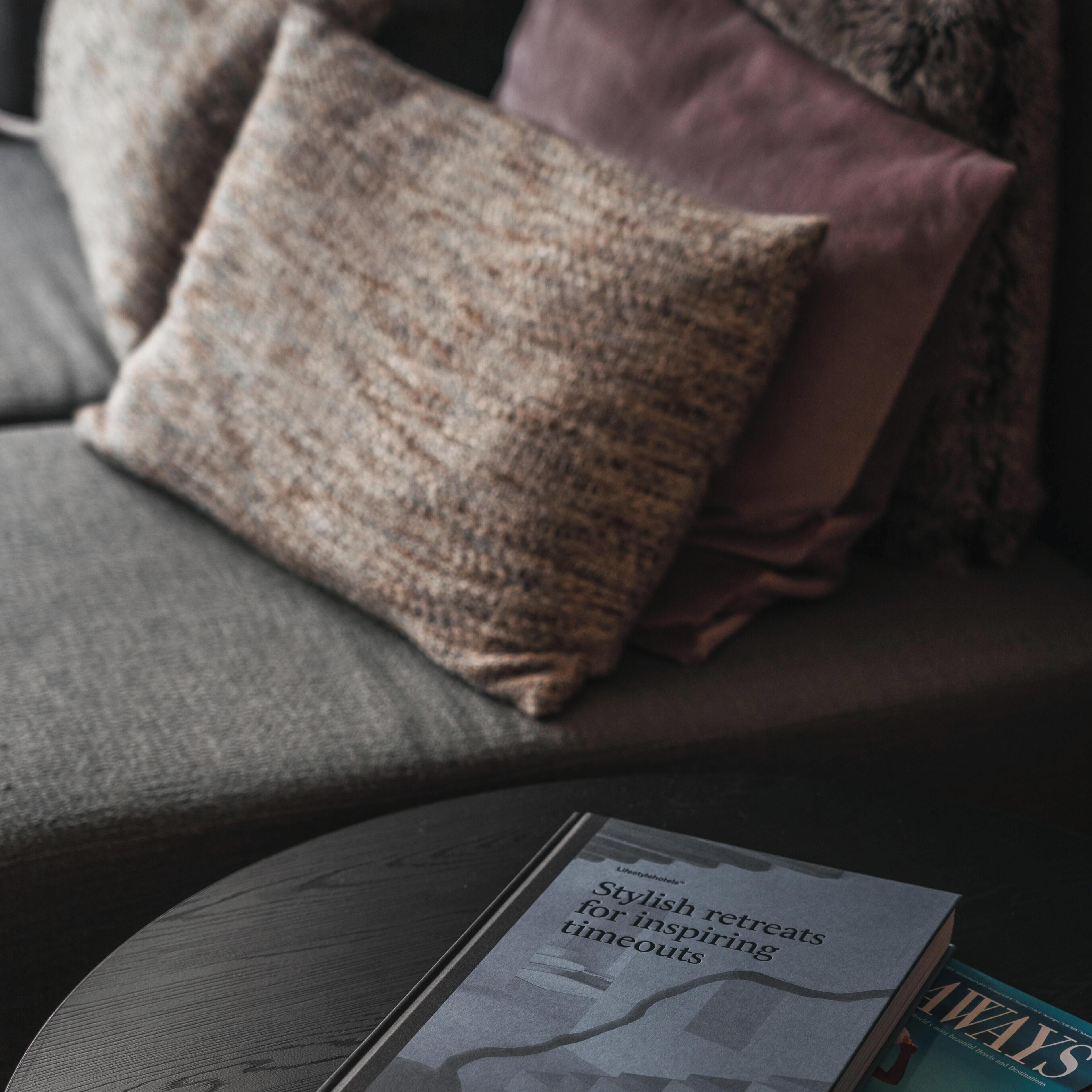 Revista sobre uma mesa, com um sofá ao fundo.