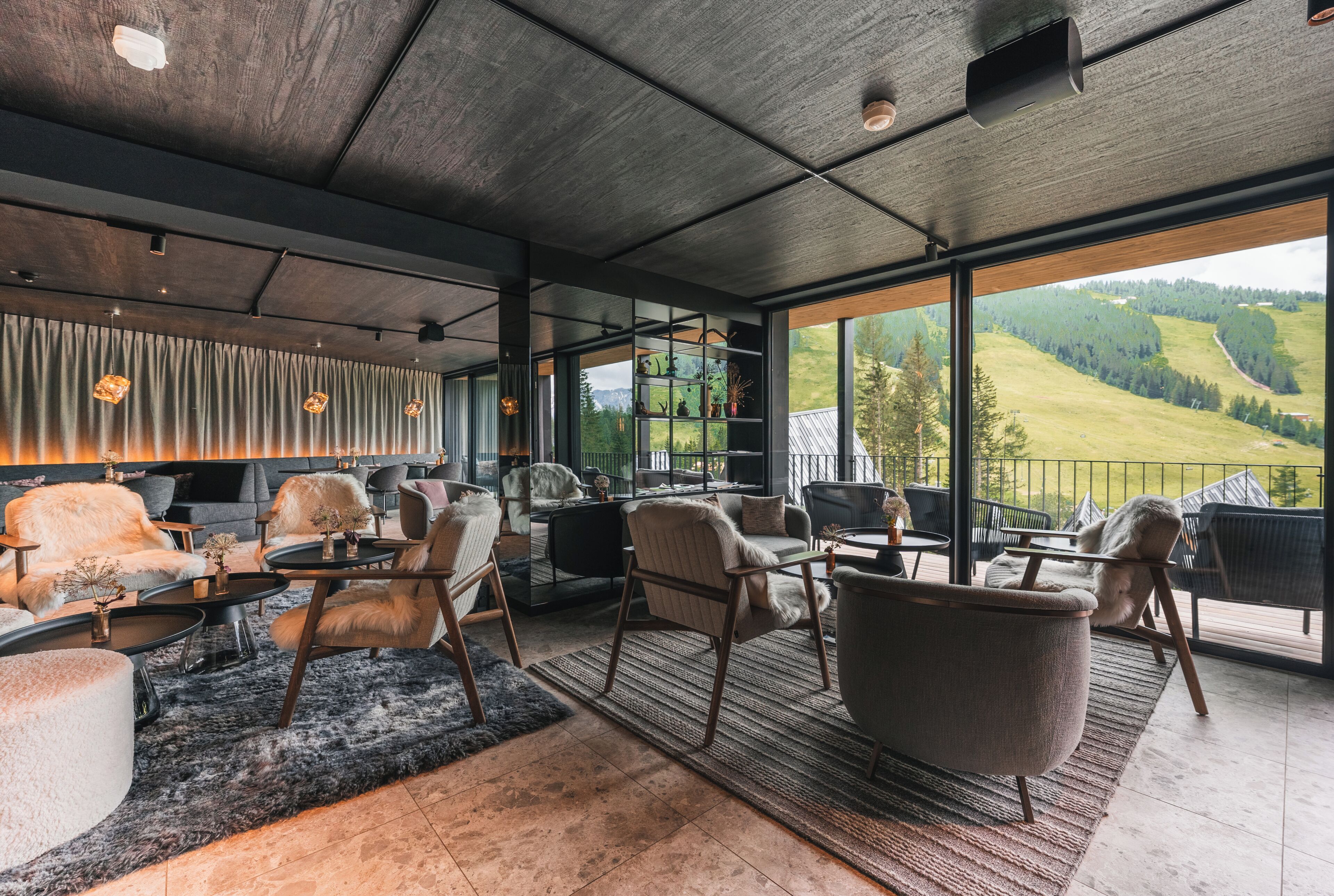 Un interior moderno con un gran ventanal, mobiliario de cuero y vistas a un paisaje verde.
