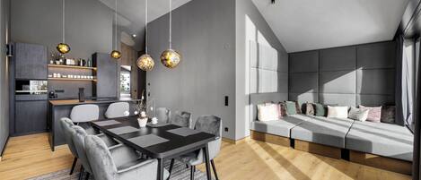 A modern interior with a dining area, kitchen, and seating area.