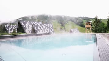 Una piscina al aire libre, sillones reclinables de piscina