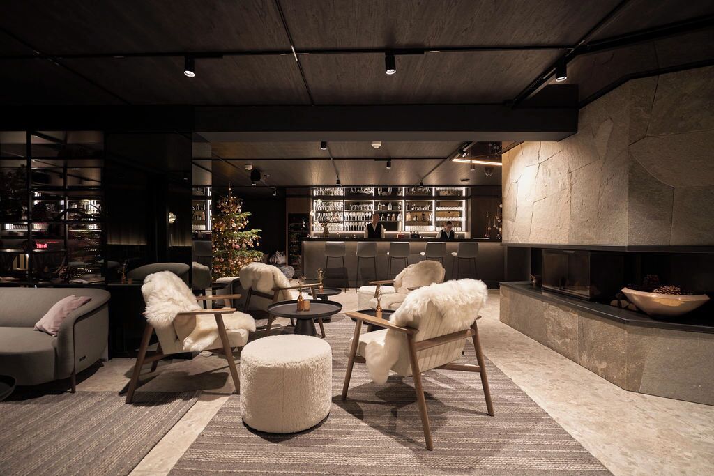 A modern lounge area with sofas, a coffee table, and a fireplace.