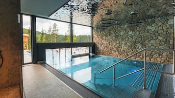 Una piscina al aire libre, sillones reclinables de piscina