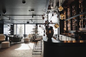 Ein modernes Interieur mit Barbereich, Sitzgelegenheiten und einem großen Fenster.