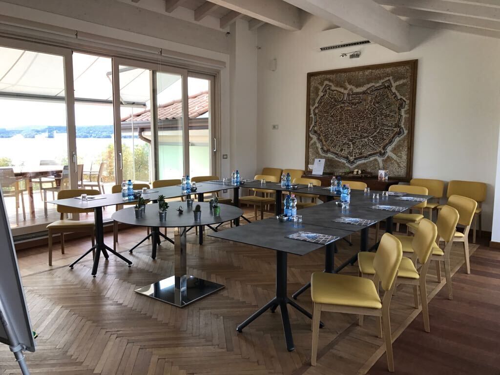 A conference room with multiple tables and chairs, large windows, and a map on the wall.