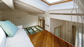 Un intérieur moderne avec une verrière, un plancher en bois et une table en verre.