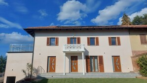 A two-story building with a balcony, multiple windows with shutters, and a small porch. - Orchid Roero Sunsetfor couples families groups to visit Roero and Langhe (Govone)