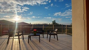 A balcony with a view of the sunset, a table with chairs, and a vase of flowers. - Orchid Roero Sunsetfor couples families groups to visit Roero and Langhe (Govone)