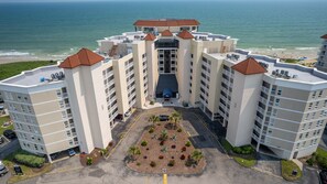 A multi-story hotel with a central courtyard, balconies, and a view of the ocean. - Best view in TOPSAIL - Luxurious 3BR Oceanfront Condo (North Topsail Beach)