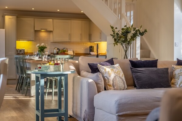 A modern living room with a sofa, a small table, and a vase of flowers.