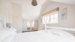 A white-themed bedroom with a large bed, a chair, and a window with a view. - Arden House - Family Luxury in Lahinch! (Lahinch)