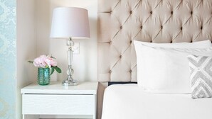 A neatly made bed with a tufted headboard, a bedside lamp, a decorative vase with flowers, and a patterned pillow. - Polanco 2BR  Skyline Balcony, Gym & Sauna (Mexico City)