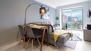 A modern living room with a dining area, a sofa, a coffee table, a lamp, and a view of the city through large windows. - Polanco 2BR  Skyline Balcony, Gym & Sauna (Mexico City)