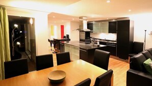Una cocina moderna con comedor, que incluye una mesa de madera y sillas negras.